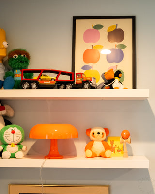 Wooden kendama on shelf with orange ball and natural wood cups and handle