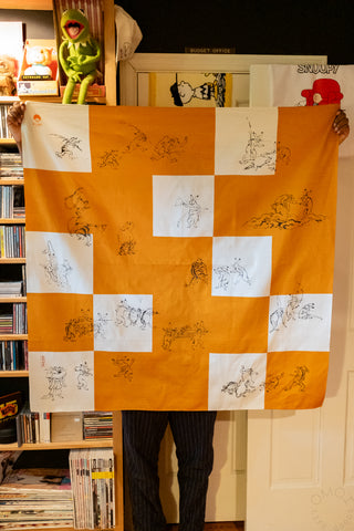 Orange and white furoshiki cloth with checkered pattern, figures in black ink