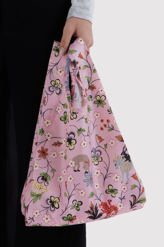 Light pink floral reusable tote bag held by hand with large open top