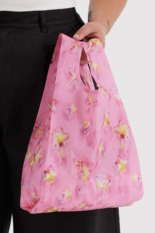 Pink star-print Baby BAGGU tote bag held by the top handles