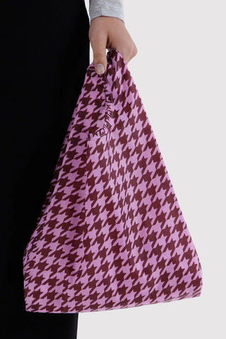 Baby BAGGU houndstooth reusable bag, pink with dark plum houndstooth, held in hand