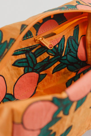 BAGGU Orange Tree dopp kit close-up with orange zipper and fruit-leaf fabric