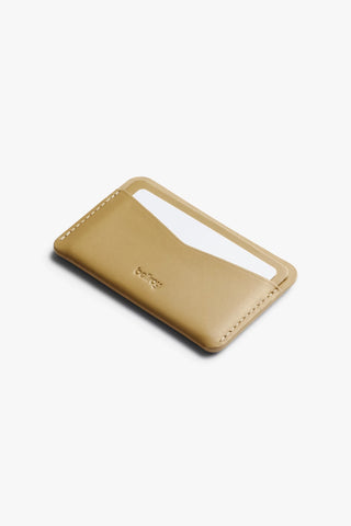 Mustard card slip wallet with elastic card slot and stitched edge, Bellroy logo.