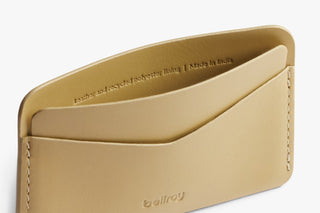 Close-up of mustard card slip interior text and stitching, Bellroy branding.