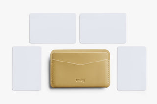 Mustard card slip wallet centered with multiple card inserts shown behind.