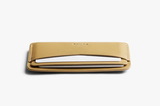 Mustard Bellroy card slip wallet lying flat with open card slot visible.