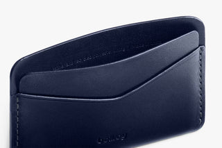 Navy leather card slip with single card sleeve and stitched edge detail