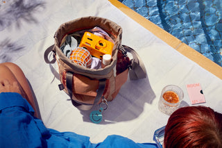 Open cinch bucket bag with tan interior and contents visible inside