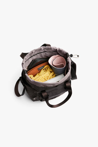 Charcoal bucket bag open to show interior compartments and drawstring closure