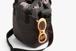 Charcoal bucket bag with front flap and orange accessory loops on exterior