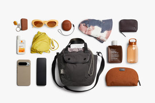Charcoal Bellroy cinch bucket bag with travel items packed in and around