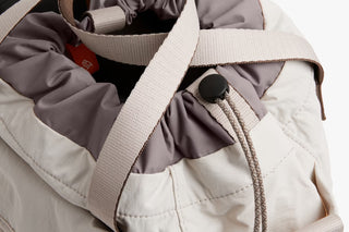Oat bucket bag with cinch cords, textured webbing strap, and spacious main compartment