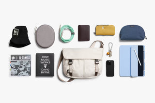 Oat light-beige messenger bag flat lay with accessories and small pouches