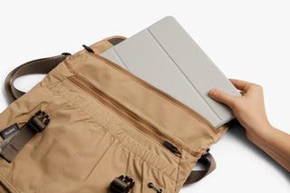Sand-beige cinch messenger bag open with top flap and padded front organizer panel
