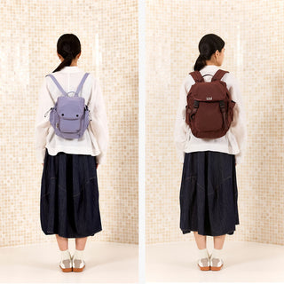 Rear view of two people wearing mini backpacks: light blue and brown