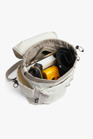 Bellroy cinch minipack backpack, oat; open top with organized compartments and gear inside