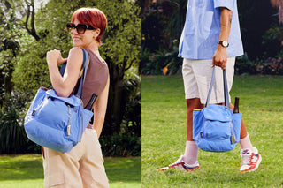 Blue tote bag worn in a garden setting, with crossbody-style strap and side pocket
