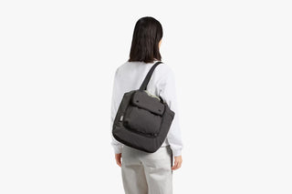 Black crossbody tote bag with adjustable strap and zip front pocket.