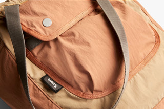Tan cinch tote inner pocket with snap button and fabric brand label