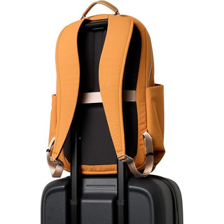 Orange daypack showing padded shoulder straps and internal compartment behind the front panel.