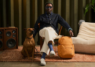 Bellroy Classic Daypack in tan on floor, front zip pocket and adjustable strap
