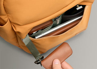 Orange daypack interior close-up with open top, lined pockets, and zipper track.