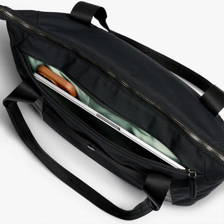 Black duffel tote bag open view, showing internal sleeve compartments and zippers.