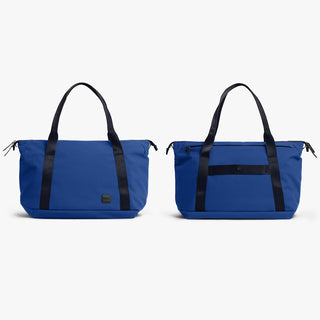 Indigo duffel bags (pair) with black handles, straps, and zippered end pockets