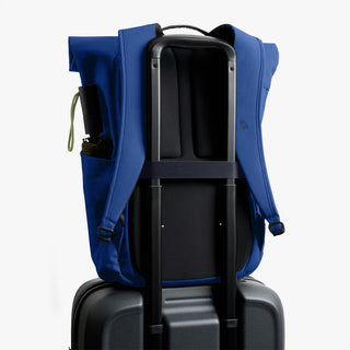 Indigo rolltop backpack with front panel and two shoulder straps, upright front view