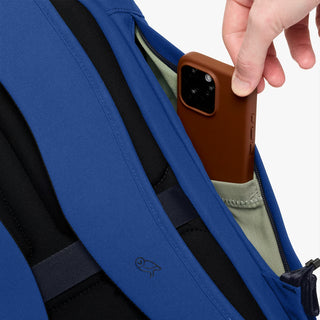 Bellroy indigo rolltop backpack close-up with phone in side slip pocket