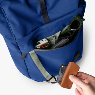 Bellroy indigo rolltop backpack side pocket with small brown key fob attached