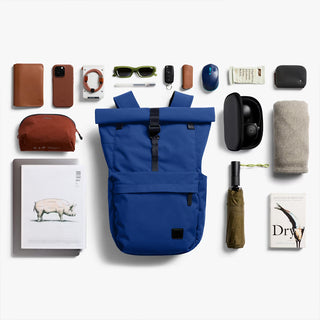 Indigo rolltop backpack laying flat, open rolltop and front pocket visible