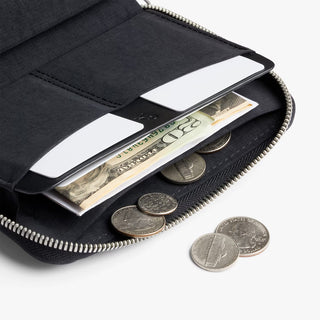 Black folio wallet open with ID card, cash, and coins in compartments