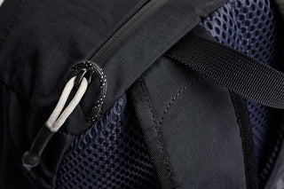 Black daypack close-up of mesh side panel and adjustable strap details