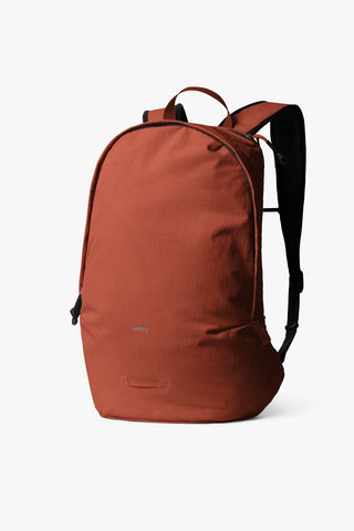 Clay-brown daypack with top handle, front zip, and adjustable shoulder straps