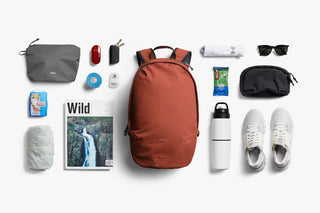 Clay-brown daypack centered with front straps and top handle visible from above