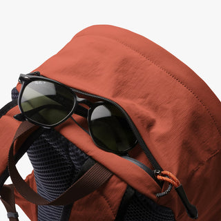 Clay daypack with zip top and shoulder straps, open pocket with sunglasses on front