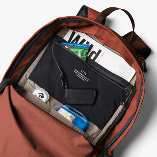 Open clay daypack interior with black organizer pockets and small front pouch