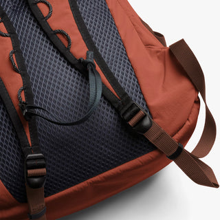 Clay-brown daypack close-up with textured back panel and adjustable shoulder straps