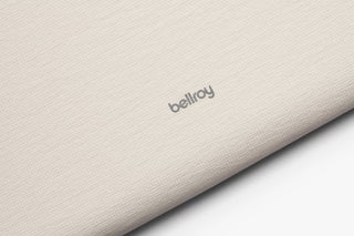 Bellroy logo on ash laptop sleeve fabric with visible zipper edge