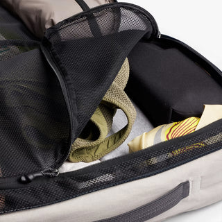 Front mesh organizer pocket inside light gray backpack with elastic strap