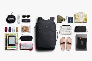 Black 30L travel backpack laid out flat, showing front pocket and top carry handle