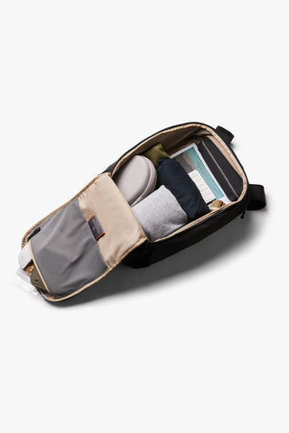 Black backpack open to show gray padded organizer pockets and accessory compartments