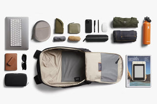 Black backpack laid open, showing internal sleeves and accessory storage layout
