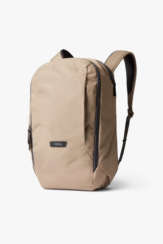 Stone-beige 20L workpack backpack with zip front and black-trim shoulder strap.