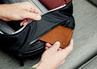 Black backpack front zip pocket with brown leather card holder and organizer inside