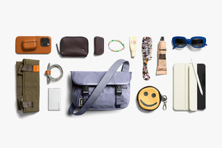 Lilac mini messenger bag flat lay with top flap, zip pocket, and adjustable strap