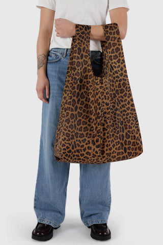 Leopard print open-top tote bag, brown with dark spots, held by model