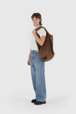 Leopard print BAGGU tote bag worn by model, brown with dark animal spots