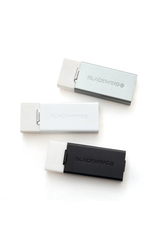 Assorted Blackwing eraser holders in black, white, and gray with clips